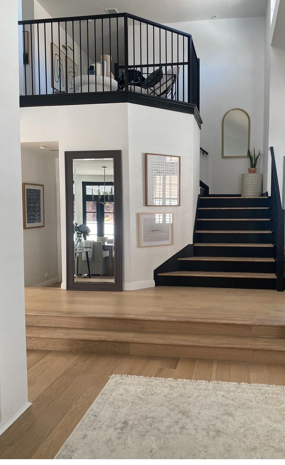 Entry with black-painted stair and railing, white oak treads and gallery art